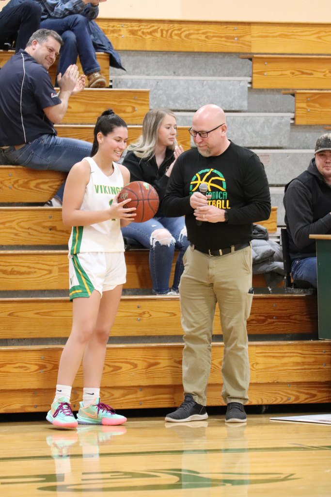Dr. Stateler presenting Chloe with a basketball dedicating her 1000 career points scored!